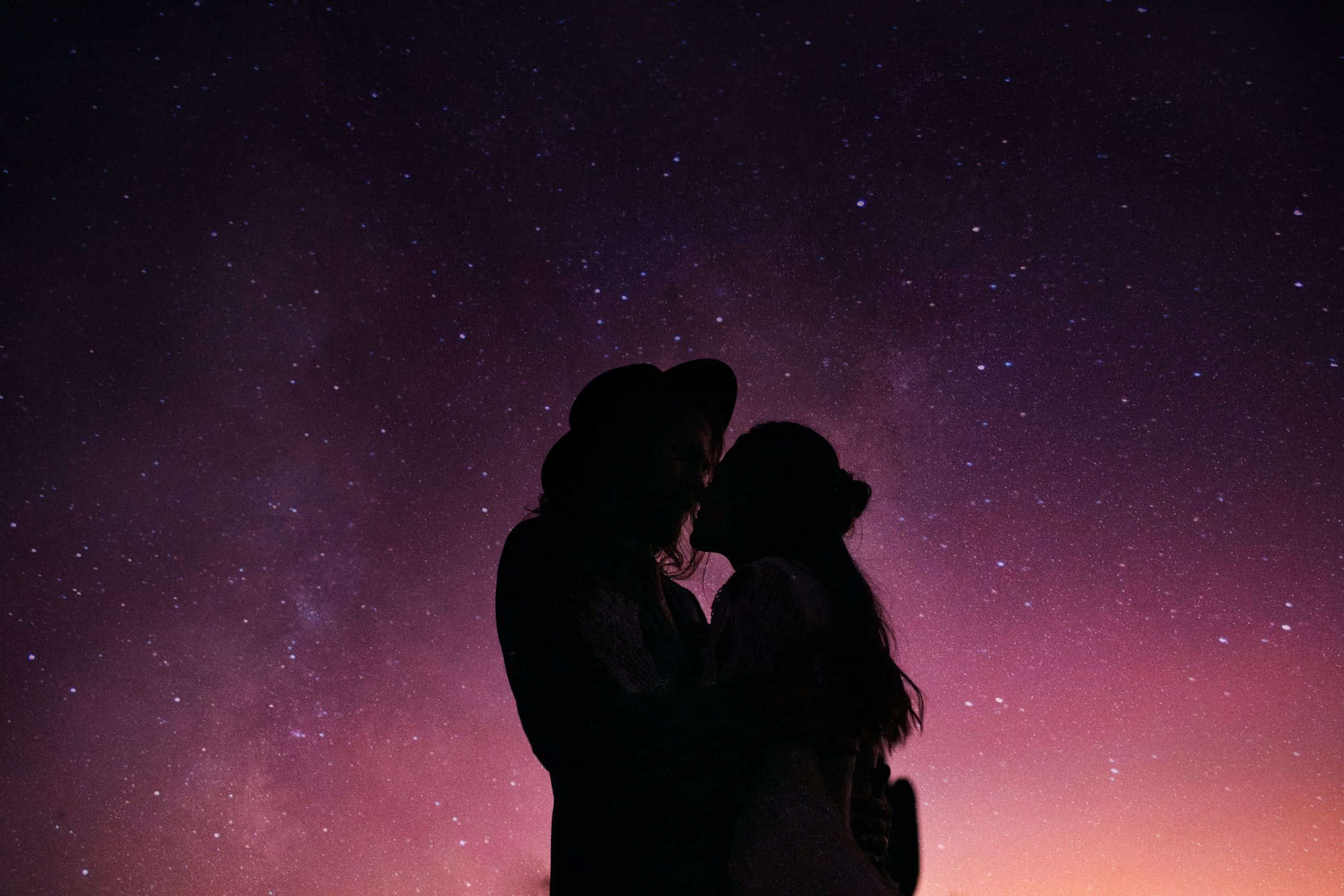 elopement couple kiss under the starry sky at night