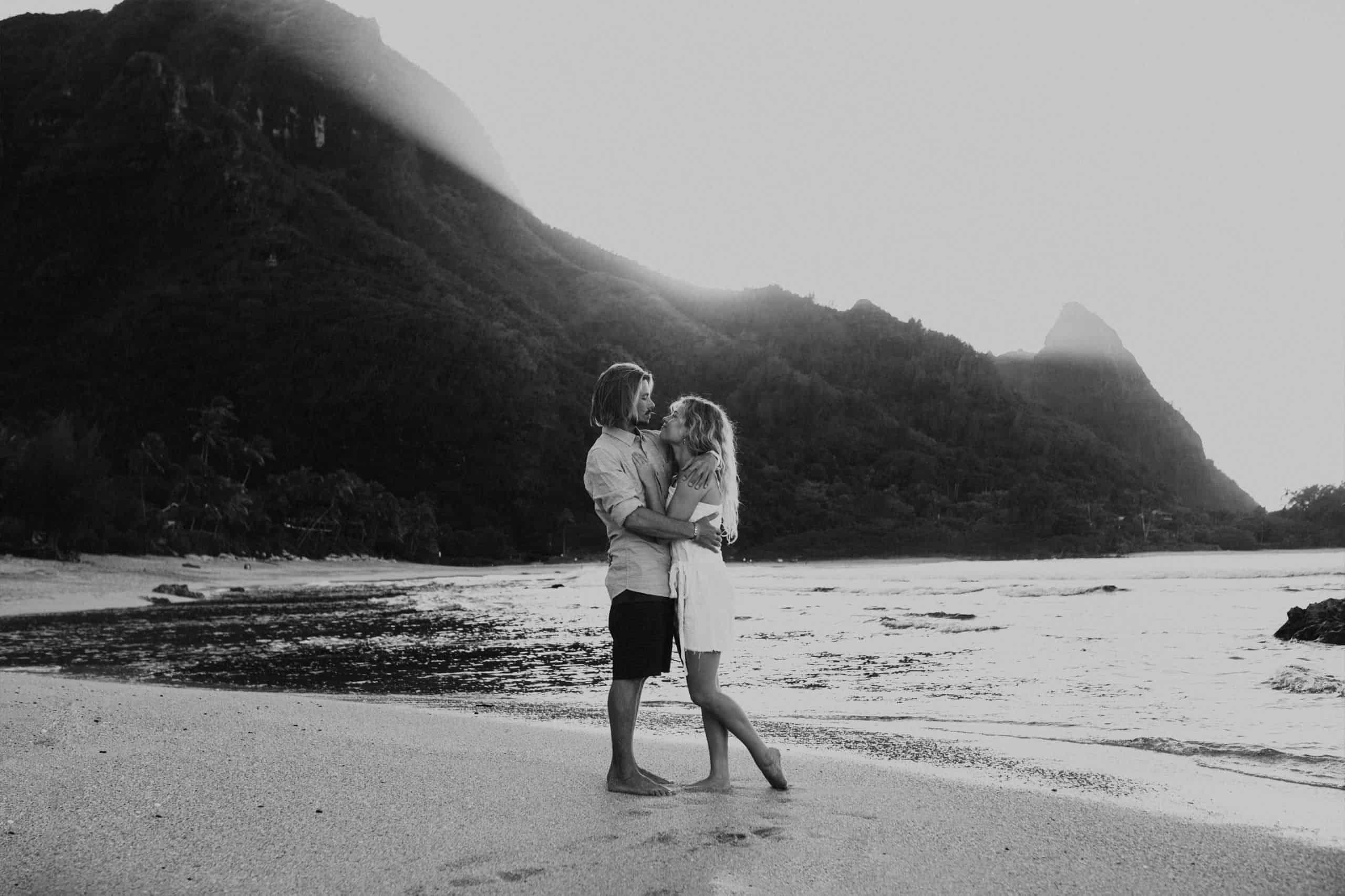 black and white image of eloping wedding couple hugging on the beach