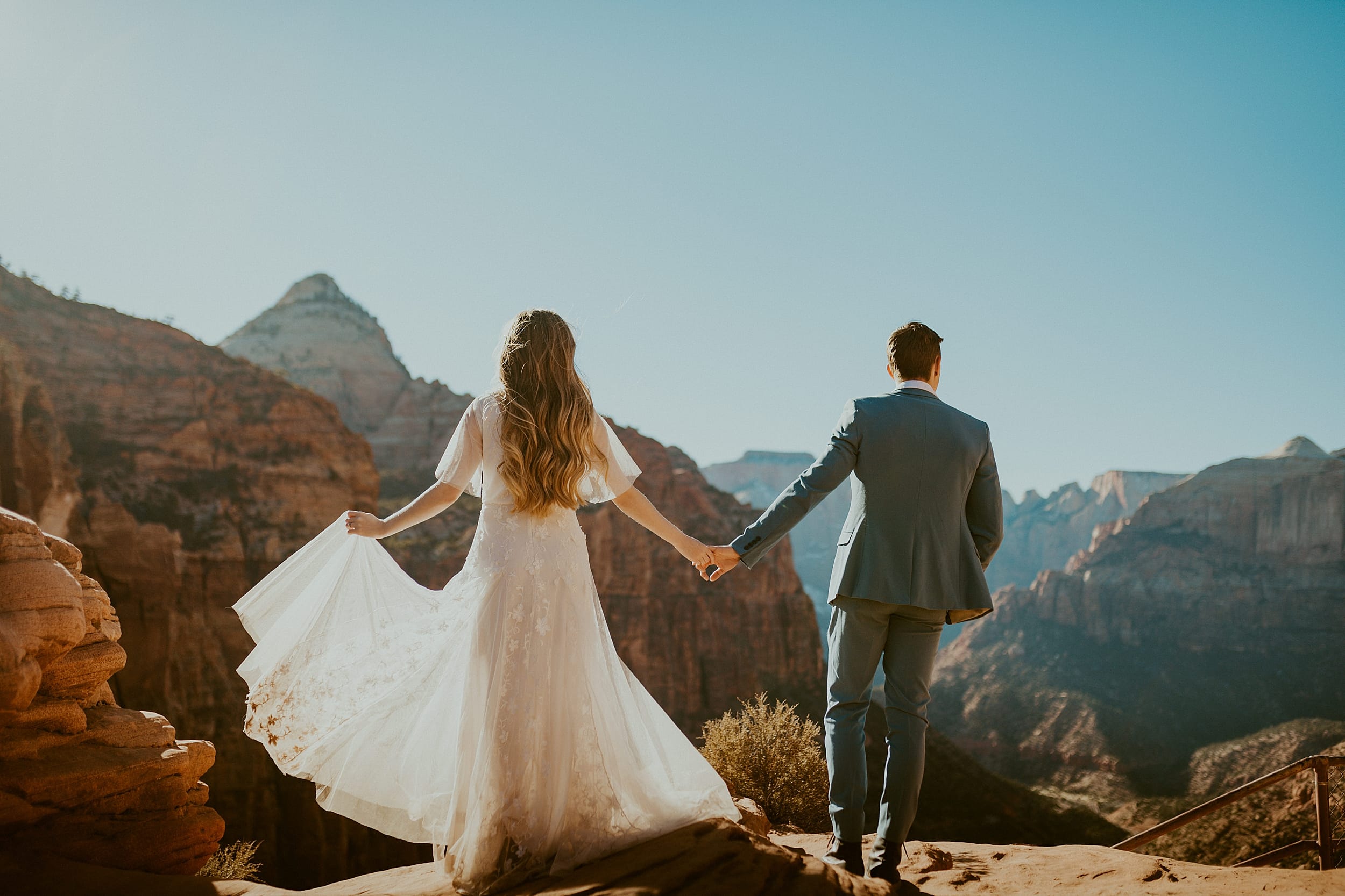 bride and groom holding hands zion national park 
