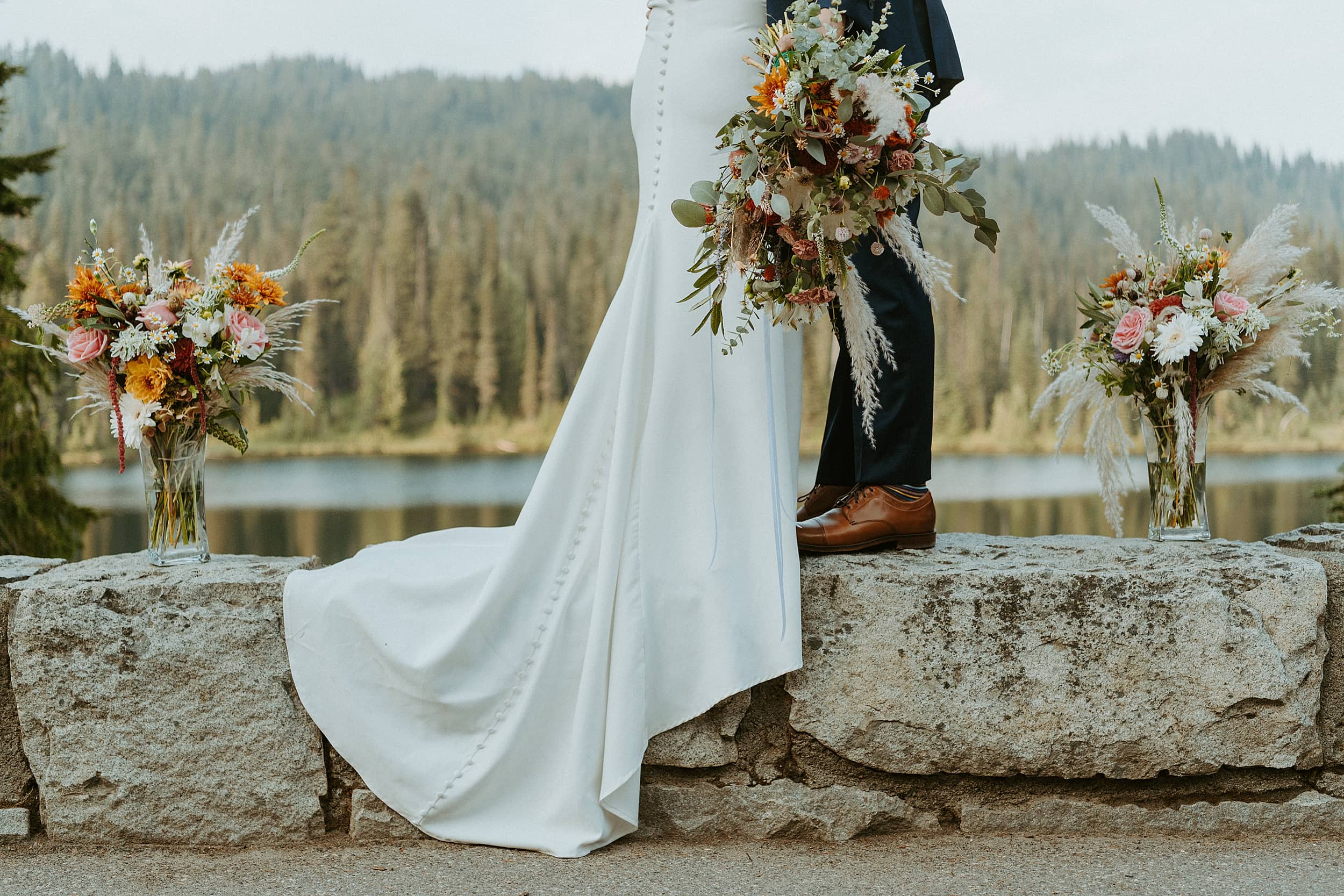 bride and groom standing together forest lake landscape bouquets 