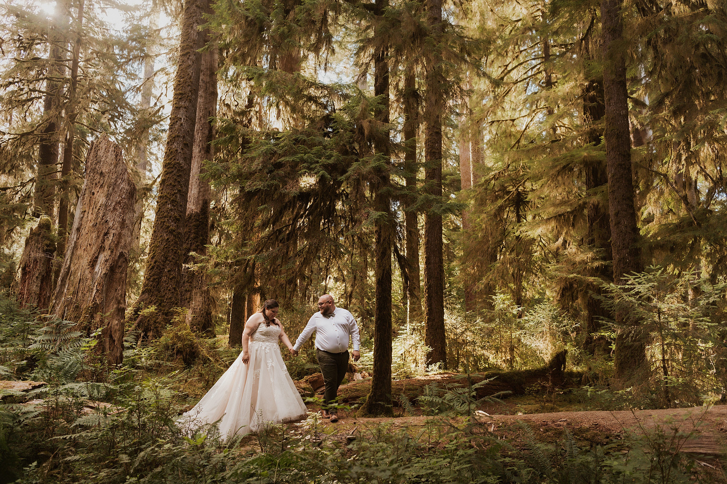 bride and groom walking on fallen trees