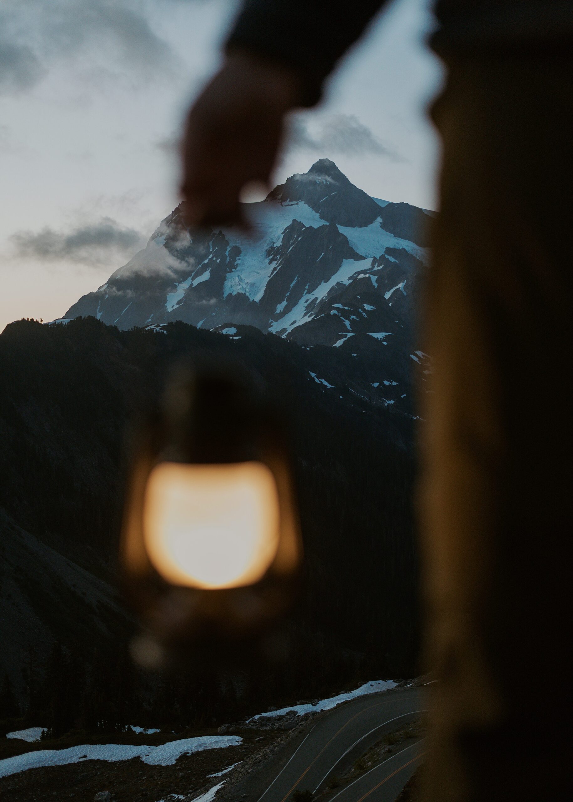 person holding lantern in front of mountain views