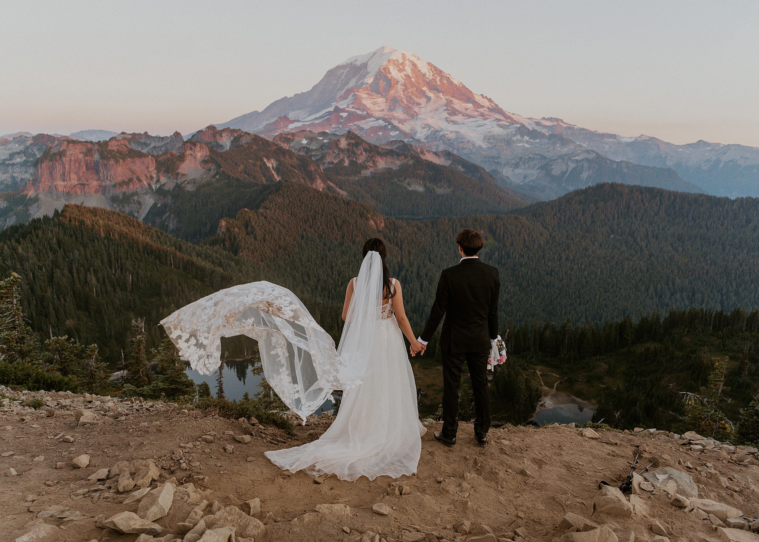 bride and groom standing in the mountains