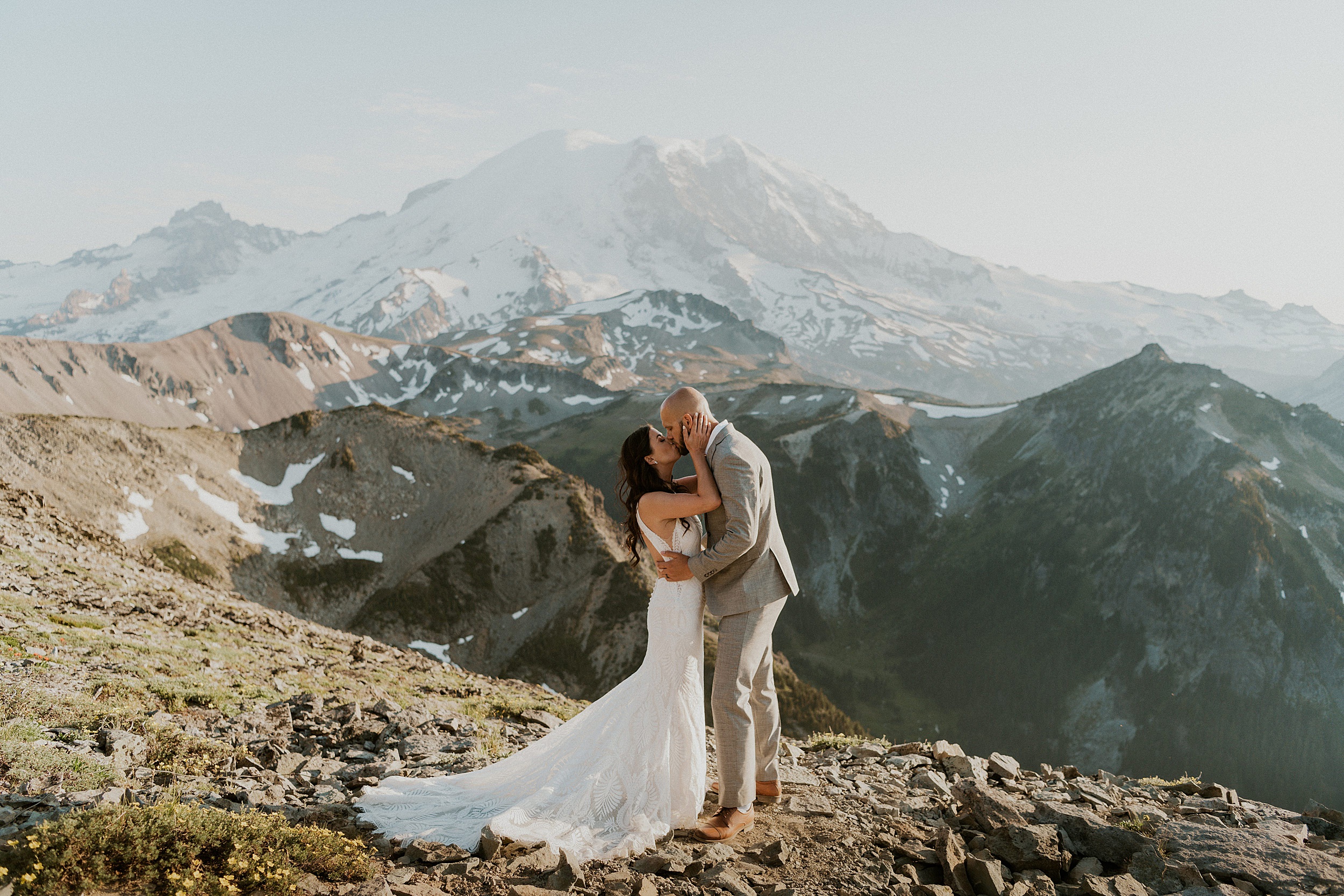 bride and groom kissing in mountains